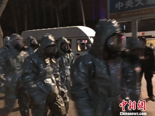 十几名身着防护服的人员头戴面具进入事发地。　胡健 摄